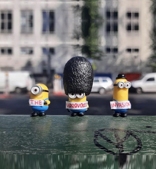 Three minion toys holding pieces of paper that say, “The Unprovoked Invasion.”