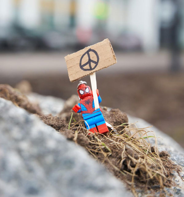 A Lego figurine holding a peace poster.